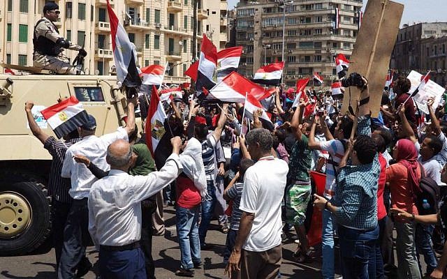 Egyptians wave the national flag in front of a military vehicle to celebrate the Suez Canal opening in Tahrir square, Cairo, Egypt. Thursday, Aug. 6, 2015. (AP Photo/Hamada Elrasam)