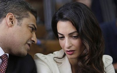 Canadian Al-Jazeera English journalist Mohammed Fahmy, left, talks to human rights lawyer Amal Clooney before his verdict in a courtroom in Tora prison in Cairo, Egypt, Saturday, Aug. 29, 2015. (AP Photo/Amr Nabil)