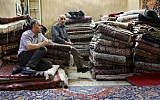 In this Monday, Aug. 10, 2015 photo, Iranian merchants wait for customers at a carpet shop in Tehran's old main bazaar, Iran. (AP Photo/Vahid Salemi)