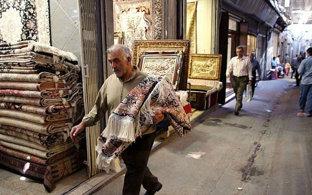 In this Monday, Aug. 10, 2015 photo, an Iranian man carries a carpet through Tehran's old main bazaar, Iran. (AP Photo/Vahid Salemi) In this Monday, Aug. 10, 2015 photo, an Iranian man carries a carpet through Tehran's old main bazaar, Iran. (AP Photo/Vahid Salemi)