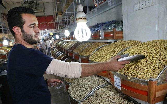 In this Monday, Aug. 10, 2015 photo, Iranian shopkeeper Emad Abri poses for a photograph next to pistachios he hopes to sell, in his shop at Tehran's old main bazaar, Iran. (AP Photo/Vahid Salemi) In this Monday, Aug. 10, 2015 photo, Iranian shopkeeper Emad Abri poses for a photograph next to pistachios he hopes to sell, in his shop at Tehran's old main bazaar, Iran. (AP Photo/Vahid Salemi)