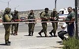 Israeli soldiers secure the scene after a Palestinian man wounded an Israeli soldier with a knife at a crossing between Israel and West Bank north of Jerusalem, August 15, 2015. (AP/Mahmoud Illean)