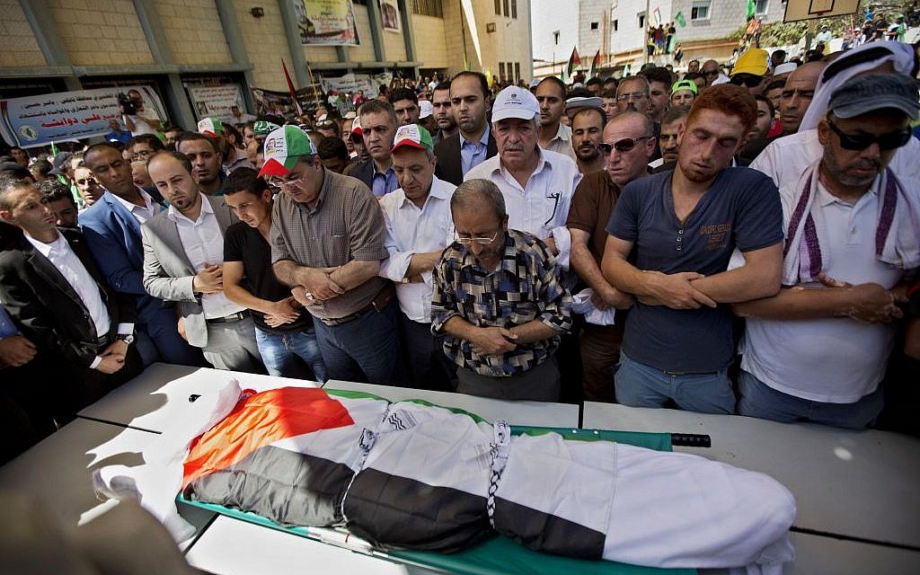 Palestinians prays by the body of Saad Dawabsha, 32, during his funeral procession in the West Bank village of Duma near Nablus on Saturday, Aug. 8, 2015. (AP Photo/Majdi Mohammed)
