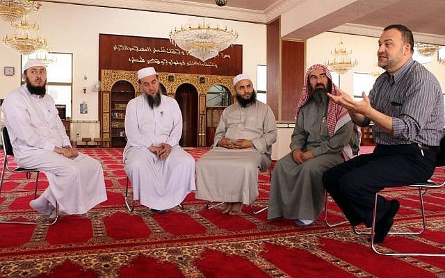In this Thursday, June 11, 2015 photo, preacher Abdel Fattah al-Madi, right, a Syrian refugee who has delivered sermons since coming to Jordan two years ago, meets with students at a mosque in Amman, Jordan. Al-Madi, who teaches in the government's training course, said he draws large crowds each Friday as word spreads about his liberal attitude. He said moderates can win the war of ideas, but that young people drawn to extremism also need practical alternatives, including jobs. (AP/Raad Adayleh) In this Thursday, June 11, 2015 photo, preacher Abdel Fattah al-Madi, right, a Syrian refugee who has delivered sermons since coming to Jordan two years ago, meets with students at a mosque in Amman, Jordan. Al-Madi, who teaches in the government's training course, said he draws large crowds each Friday as word spreads about his liberal attitude. He said moderates can win the war of ideas, but that young people drawn to extremism also need practical alternatives, including jobs. (AP/Raad Adayleh)