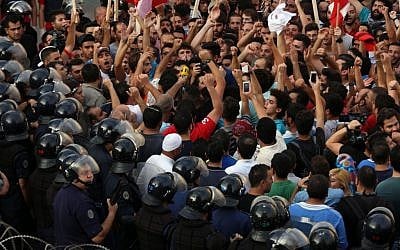 Activists chant slogans as Lebanese riot policemen stand guard in front the government house during a protest against the ongoing trash crisis, in downtown Beirut, Lebanon, Saturday, August 22, 2015. (AP/Bilal Hussein)