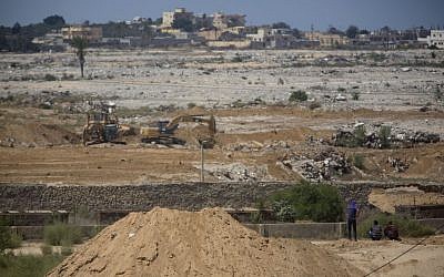 In this Sunday, Aug. 30, 2015 photo, bulldozers and diggers work at the Egyptian side of the border with Gaza Strip. (AP Photo/Khalil Hamra)