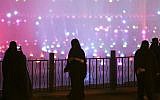 In this March 29, 2014, file photo, a Saudi woman takes photographs in a park during celebrations to mark the worldwide Earth Hour in Riyadh, Saudi Arabia. (AP/Hasan Jamali)