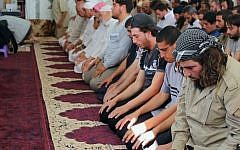 In this photo provided Friday, Aug. 7, 2015, by the Rased News Network, a Facebook page affiliated with Islamic State militants, Muslim worshipers attend Friday prayers in a mosque in the central Syrian town of Qaryatain. (Rased News Network, a Facebook page affiliated with Islamic State militants via AP)