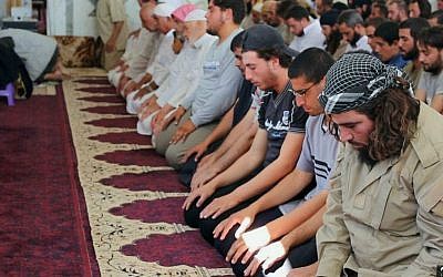 In this photo provided Friday, Aug. 7, 2015, by the Rased News Network, a Facebook page affiliated with Islamic State militants, Muslim worshipers attend Friday prayers in a mosque in the central Syrian town of Qaryatain. (Rased News Network, a Facebook page affiliated with Islamic State militants via AP)
