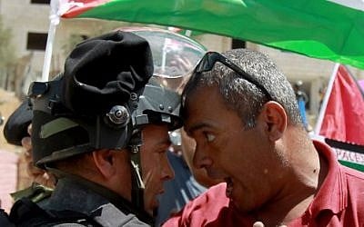 A Palestinian protester scuffles with an Israeli border policeman during during clashes following a demonstration against the West Bank security fence in the mainly Christian village of Beit Jala, on August 30, 2015. (Musa Al Shaer/ AFP)