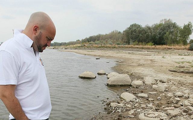 Jonny Daniels, head of the Jewish foundation “From the Depths,” finds fragments of Jewish tombstones with Hebrew lettering along the Vistula River in Warsaw, Poland, on Aug. 25, 2015. (AP Photo/Czarek Sokolowski)