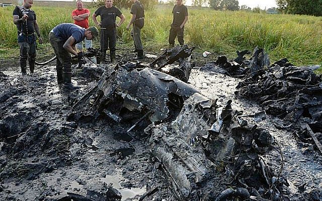 In this Aug. 23, 2015 photo made available by the firefighter brigade in Wyszogrod, central Poland, firefighters are retrieving the remains of a Soviet WWII fighter-bomber plane from a muddy riverbed near Wyszogrod. (AP Photo/OSP Wyszogrod)