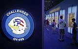 In this Tuesday, July 21, 2015 photo, visitors look over display cases at the "Forever Remembered" exhibit and memorial for the astronauts that perished on the Columbia and Challenger space shuttles, at the Kennedy Space Center Visitor Complex in Cape Canaveral, Florida. (AP Photo/John Raoux)