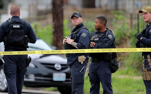 St. Louis police gather at the scene of a fatal officer-involved shooting at Walton Avenue and Page Boulevard, Wednesday, Aug. 19, 2015 in St. Louis. An armed man fleeing from officers serving a search warrant at a home in a crime-troubled section of north St. Louis was shot and killed Wednesday by police after he pointed a gun at them, the police chief said. (David Carson/St. Louis Post-Dispatch via AP) St. Louis police gather at the scene of a fatal officer-involved shooting at Walton Avenue and Page Boulevard, Wednesday, Aug. 19, 2015 in St. Louis. An armed man fleeing from officers serving a search warrant at a home in a crime-troubled section of north St. Louis was shot and killed Wednesday by police after he pointed a gun at them, the police chief said. (David Carson/St. Louis Post-Dispatch via AP)