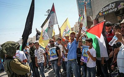 Israeli soldiers argue with Palestinian protesters blocking a road near the village of Palestinian prisoner, Mohammad Allaan, near Nablus, August 15, 2015 (Flash90)  