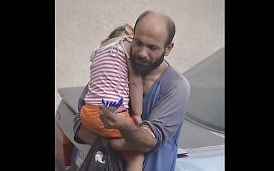 This image of Syrian-Palestinian refugee Adul Attar carrying his daughter while selling pens on the streets of Beirut went viral in August 2015, leading to donations of more than $116,000. (screen capture: YouTube)