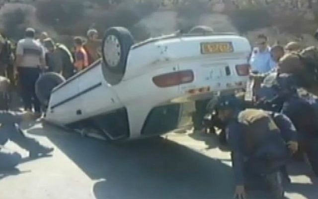 Security forces inspect the car used in a vehicular terror attack in the West Bank on Thursday, August 6, 2015. The terrorist was trapped inside. (screen capture: Channel 2)