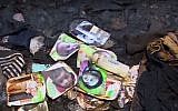 Family photos lie in the remains of the Dawabsha home in the West Bank village of Duma, after it was firebombed by suspected Jewish extremists on July 31, 2015. The family's 18-month-old baby was killed in the attack and his father died of his injuries eight days later, on August 8, 2015. (screen capture: YouTube)
