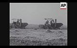 Combines roll through the fields as Israel harvests its first crops from the Negev in 1956 (Screenshot of newsreel footage from YouTube)