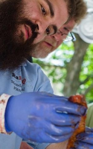 Rabbi Mendel Segal and teammate Duane Dougherty checking the tenderness of the rabbi’s brisket at the 2014 Liberty 4th Fest BBQ Contest in Liberty, Mo. (Courtesy of Mendel Segal)
