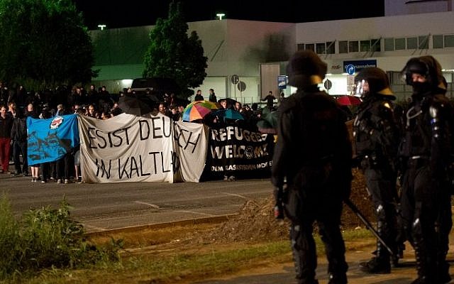 Police face far-right activists protesting the opening of a new center for refugees on August 22, 2015 in Heidenau, Germany, a day after similar standoffs left dozens wounded. (AFP PHOTO / DPA / ARNO BURGI)