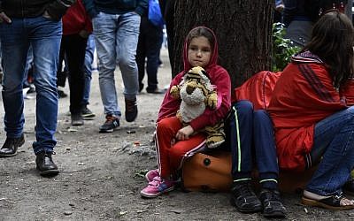 A migrant child sits outside the State Office of Health and Social Affairs in Berlin (LAGeSo) where hundreds of migrants wait to receive help from the Berlin administration on August 25, 2015. (AFP PHOTO / TOBIAS SCHWARZ)