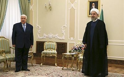 Hassan Rouhani, right, waited for the Syrian delegation as he was meeting with Syrian Foreign Minister Walid al-Moallem, left, at the presidency office in Tehran on Wednesday, Aug 5, 2015. (Vahid Salemi/ AP)