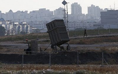 An IDF soldier walks past an "Iron Dome" battery, a short-range missile defense system, designed to intercept and destroy incoming short-range rockets and artillery shells, on August 20, 2015, in the city of Ashdod. (AFP PHOTO / AHMAD GHARABLI)