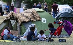 Illustrative: Refugees wait outside the refugee camp in Traiskirchen, Austria, Friday, July 31, 2015. (AP Photo/Ronald Zak)