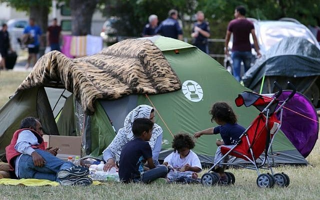 Illustrative: Refugees wait outside the refugee camp in Traiskirchen, Austria, Friday, July 31, 2015. (AP Photo/Ronald Zak) Illustrative: Refugees wait outside the refugee camp in Traiskirchen, Austria, Friday, July 31, 2015. (AP Photo/Ronald Zak)