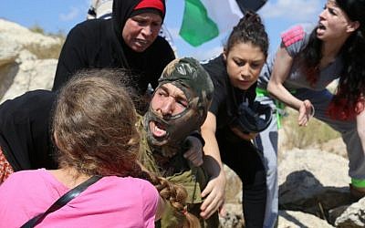 Palestinians  fight to stop an IDF soldier from arresting a 12-year-old boy with a broken arm in a cast accused of throwing stones (Eric Cortellessa/Times of Israel)