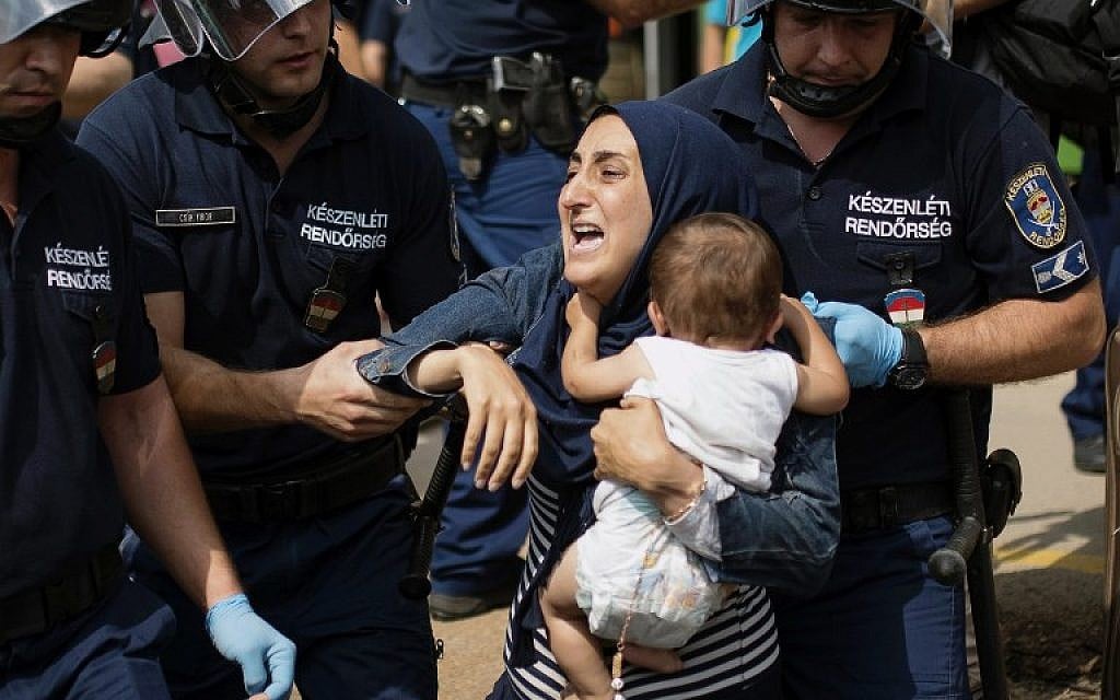 A migrant family is arrested by local police after their local train coming from Budapest and heading to the Austrian border has been stopped in Bicske, west of the Hungarian capital on September 3, 2015. (AFP/ISTVAN BIELIK)