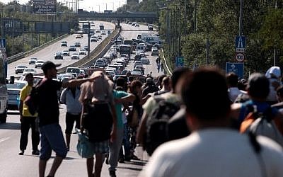 Hundreds of migrants walk on a highway after leaving the transit zone of the Budapest main train station, on September 4, 2015 intenting on walking to the Austrian border. (AFP/ FERENC ISZA)