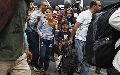 A migrant boy eats bread upon arrival at the Westbahnhof railroadstation in Vienna, on September 5, 2015  as hundreds of migrants arrive by bus and train from Hungary to continue their journey to Germany.  (AFP PHOTO/DIETER NAGL)