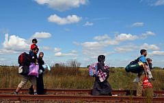 Migrant families walk at the railway track at the Hungarian-Serbian border near Roszke village on September 6, 2015. (AFP/CSABA SEGESVARI)