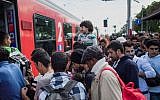 Illustrative: Migrants enter a train heading to Salzburg at Nickelsdorf, eastern Austria, on September 6, 2015. (AFP/VLADIMIR SIMICEK)
