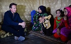 Britain's Prime Minister David Cameron (L) meets Syrian refugee families at a tented settlement camp in the Bekaa Valley on the Lebanese-Syrian border on September 14, 2015. (AFP PHOTO/POOL/STEFAN ROUSSEAU)