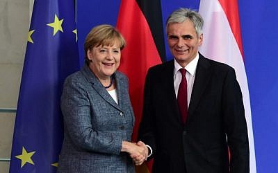 German Chancellor Angela Merkel and her Austrian counterpart Werner Faymann shake hands following a press conference at the Chancellery in Berlin on September 15, 2015, after their meeting on the refugee crisis. (AFP PHOTO / JOHN MACDOUGALL)