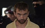 In this photo taken on September 5, 2015, a suspect identified by officials as Adem Karadag, is escorted by Thai commandos upon his arrival at a court in Bangkok. (AFP PHOTO/PORNCHAI KITTIWONGSAKUL/FILES)