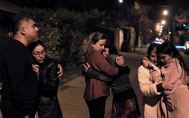 People remain in the street during a strong quake in Santiago on September 16, 2015.(AFP PHOTO /ALEJANDRO RUSTON)