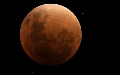 View of the moon during a full eclipse in Buenos Aires on September 27, 2015 (AFP PHOTO / JUAN MABROMATA)