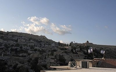 Israeli flags flying above the home of Palestinian family Abu Snineh, whose building was taken over by Jewish residents in the Silwan neighborhood of East Jerusalem, August 30, 2015. (AFP/Ahmad Gharabli)