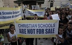 Hundreds of Israeli Christians hold banners in a rally against what they said was state discrimination in funding their schools, at the foot of the Basilica of the Annunciation in Nazareth on September 1, 2015 (Ahmad Gharabli/AFP)