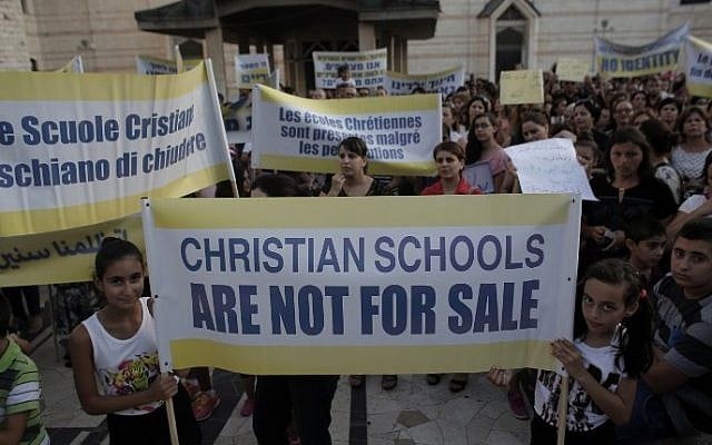 Hundreds of Israeli Christians hold banners in a rally against what they said was state discrimination in funding their schools, at the foot of the Basilica of the Annunciation in Nazareth on September 1, 2015 (Ahmad Gharabli/AFP) Hundreds of Israeli Christians hold banners in a rally against what they said was state discrimination in funding their schools, at the foot of the Basilica of the Annunciation in Nazareth on September 1, 2015 (Ahmad Gharabli/AFP)