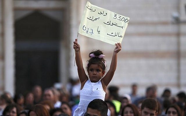 An Arab-Israeli Christian child holds a banner during a rally against alleged state discrimination in funding of Christian schools at the foot of the Basilica of the Annunciation in Nazareth on September 1, 2015. (AFP/AHMAD GHARABLI) An Arab-Israeli Christian child holds a banner during a rally against alleged state discrimination in funding of Christian schools at the foot of the Basilica of the Annunciation in Nazareth on September 1, 2015. (AFP/AHMAD GHARABLI)