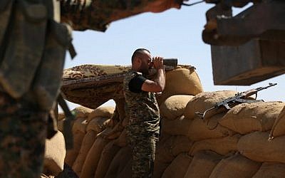 File: A fighter from the Kurdish People Protection Unit (YPG) uses binoculars on the front line in the northeastern Syrian city of Hasakeh on September 4, 2015. (Delil Souleiman/AFP)