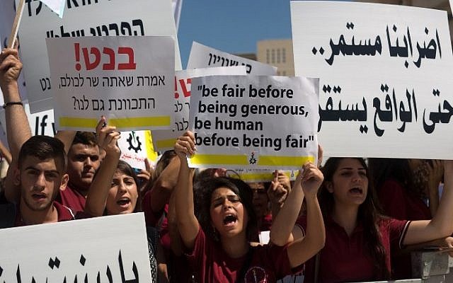Arab Israeli Christian students hold placards during a protest in Jerusalem to demand more funds for Christian schools, on September 6, 2015. (AFP/Menahem Kahana) Arab Israeli Christian students hold placards during a protest in Jerusalem to demand more funds for Christian schools, on September 6, 2015. (AFP/Menahem Kahana)