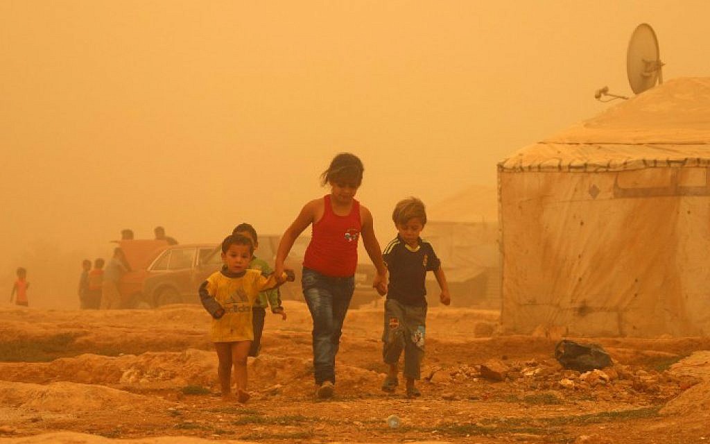 Syrian children walk amid the dust during a sandstorm on September 7, 2015 at a refugee camp on the outskirts of the eastern Lebanese city of Baalbek. (AFP Photo/STR) Syrian children walk amid the dust during a sandstorm on September 7, 2015 at a refugee camp on the outskirts of the eastern Lebanese city of Baalbek. (AFP Photo/STR)
