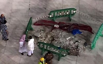 Saudi emergency teams gather inside the Grand Mosque of Saudi Arabia's holy Muslim city of Mecca next to a piece of a construction crane after it crashed into the mosque on September 11, 2015, killing more than 100 people. (AFP PHOTO/STR)