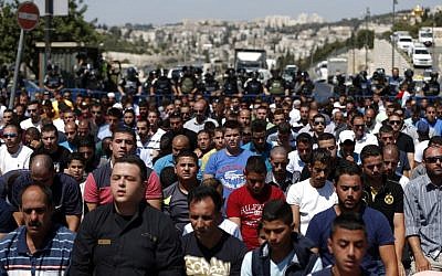 Israeli security forces stand guard as Palestinian Muslim worshipers take part in Friday noon prayers in the East Jerusalem neighborhood of Ras al-Amud on September 18, 2015, (AFP PHOTO/AHMAD GHARABLI)